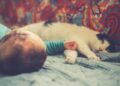 white and black cat lying beside baby | cats and babies friendship tips | Discover effective strategies to ensure a smooth introduction between your cat and new baby. This guide provides essential tips for creating a harmonious environment that fosters friendship and safety for both. | Can Cats and Babies Become Friends? Essential Tips